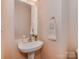 Neat bathroom with a classic pedestal sink and decorative towel hanger at 244 Hurston Cir, Charlotte, NC 28208