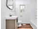 Well-lit bathroom features a window, vanity with storage, and tiled walls at 2548 Milton Ave, Gastonia, NC 28052