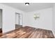 Bright bedroom featuring hardwood floors, white walls, and mirrored closet doors at 2548 Milton Ave, Gastonia, NC 28052