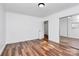 A bright bedroom featuring hardwood floors, white walls, and closet doors at 2548 Milton Ave, Gastonia, NC 28052