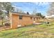 Side view of a brick home with a modest backyard and a detached shed at 2548 Milton Ave, Gastonia, NC 28052