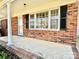Inviting front porch with classic brick accents, featuring a large window and a storm door at 2604 Oxford Cir, Lancaster, SC 29720