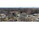 A high aerial shot of the house and its neighborhood, complete with mature trees and Charlotte skyline in view at 4201 Winedale Ln, Charlotte, NC 28205