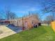 Home featuring a well-maintained backyard, a brick exterior, and a concrete patio at 4201 Winedale Ln, Charlotte, NC 28205