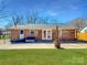Large backyard with a brick exterior, offering an open patio space for outdoor activities and gatherings at 4201 Winedale Ln, Charlotte, NC 28205