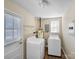Well-lit laundry room featuring a washer, a dryer, and storage shelves at 4201 Winedale Ln, Charlotte, NC 28205