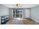 Bright living room features laminate flooring, a ceiling fan, and a large window overlooking the front yard at 4201 Winedale Ln, Charlotte, NC 28205