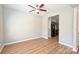 Bright, empty bedroom featuring wood-look flooring, a ceiling fan, and a view to the kitchen at 530 Pate Dr, Fort Mill, SC 29715
