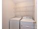 Bright laundry room features a white washer, dryer and wire shelving at 530 Pate Dr, Fort Mill, SC 29715