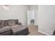 Living room space featuring a gray sofa with decorative pillows, carpeted floors, and a door with shoe shelving in the background at 558 Rough Hewn Ln, Rock Hill, SC 29730
