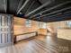 Open basement area boasts knotty pine walls, black ceiling and beams, and luxury vinyl flooring at 719 Washington St, Cramerton, NC 28032