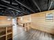 Knotty pine basement with an open floor plan features black ceilings and wood-look luxury vinyl flooring at 719 Washington St, Cramerton, NC 28032