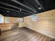 Spacious basement featuring paneled walls, wood-look vinyl floor, and painted black ceiling and joists at 719 Washington St, Cramerton, NC 28032