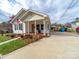 Well-maintained home with a classic front porch, surrounded by lush landscaping and a concrete driveway at 719 Washington St, Cramerton, NC 28032