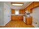 Bright kitchen with wood cabinets, white appliances, and updated flooring at 7311 Dogwood Ln, Kannapolis, NC 28081