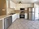 Well-equipped kitchen with white cabinetry, stainless steel appliances, and tile flooring at 807 Limerick Dr, Dallas, NC 28034