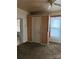 Bedroom with wood-paneled walls, closet, window and access to other rooms at 1010 13Th St # 11, Lancaster, SC 29720