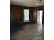 View of the living room with wood paneling, wood floor, ceiling fan and exterior access door at 1010 13Th St # 11, Lancaster, SC 29720