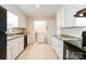 Well-lit kitchen features white cabinets, black appliances, neutral countertops and tile floors at 1052 Palmyra Dr, Fort Mill, SC 29708