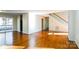 Living room with gleaming hardwood floors, leading to a sliding glass door and a staircase with white railings at 1052 Palmyra Dr, Fort Mill, SC 29708