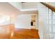 Bright living room features gleaming hardwood floors, staircase with white railings and a view into the kitchen at 1052 Palmyra Dr, Fort Mill, SC 29708