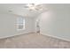 Bright bedroom with plush carpet, a ceiling fan, and a window at 107 Adams Tree Way, Troutman, NC 28166