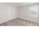 Well-lit bedroom boasts neutral carpet, double door closet and a window at 107 Adams Tree Way, Troutman, NC 28166