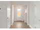 Bright entryway with wood-look flooring, a glass-paneled front door, and staircase at 107 Adams Tree Way, Troutman, NC 28166