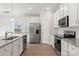Well-lit kitchen showcasing stainless steel appliances, granite countertops, and white cabinetry at 107 Adams Tree Way, Troutman, NC 28166