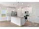 Modern kitchen with white cabinets, stainless steel appliances, granite countertops and island at 107 Adams Tree Way, Troutman, NC 28166