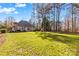 Expansive backyard with a well-maintained lawn, mature trees, and the rear exterior of the house at 109 Gannett Dr, Mooresville, NC 28117