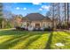 Well-maintained backyard featuring a lush green lawn, mature trees, and the rear exterior of the house at 109 Gannett Dr, Mooresville, NC 28117