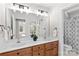 Bright bathroom with a double sink vanity, wooden cabinets and a large mirror reflecting another room at 109 Gannett Dr, Mooresville, NC 28117