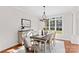 Bright dining room featuring hardwood floors, updated chandelier and large windows overlooking a landscaped lawn at 109 Gannett Dr, Mooresville, NC 28117