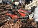 An outdoor lawn tractor sitting on a pile of leaves in the yard near some equipment at 109 Pembrooke Trl # F171, Mount Gilead, NC 27306