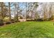 Green backyard is meticulously maintained with lush grass and mature trees, providing privacy at 11311 Mcclure Manor Dr, Charlotte, NC 28277