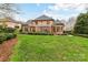 Expansive backyard features a pergola, manicured landscaping, and direct access to the main house at 11311 Mcclure Manor Dr, Charlotte, NC 28277