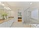 Bathroom with double sinks and a view into the connecting bedroom with a tub and shower at 11311 Mcclure Manor Dr, Charlotte, NC 28277