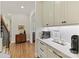 Hallway view of a coffee bar with white cabinets and drawers, along with hardwood floors at 11311 Mcclure Manor Dr, Charlotte, NC 28277