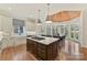 Open concept kitchen with large island, cooktop, farm sink, and breakfast nook with view of landscaped backyard at 11311 Mcclure Manor Dr, Charlotte, NC 28277