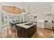Bright kitchen with large island cooktop, white cabinets, stainless fridge, and sunny breakfast nook with beautiful chandelier at 11311 Mcclure Manor Dr, Charlotte, NC 28277