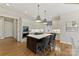 Stylish kitchen with white cabinets, dark island with cooktop, bar stool seating, and stainless steel oven at 11311 Mcclure Manor Dr, Charlotte, NC 28277
