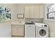 Well-equipped laundry room with white cabinets, sink, and modern washer and dryer units at 11311 Mcclure Manor Dr, Charlotte, NC 28277