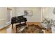 A bright living room showcases hardwood floors, a black piano, and a leather rug at 11311 Mcclure Manor Dr, Charlotte, NC 28277