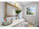 Elegant bathroom featuring a vanity with sink, ornate mirror, fresh flowers, and ample natural light at 1148 Turnbridge Rd, Charlotte, NC 28226