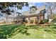 Attractive brick home featuring dormer windows, mature trees, and a lush lawn on a sunny day at 1148 Turnbridge Rd, Charlotte, NC 28226