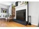 Living room featuring a black brick fireplace with white mantel, hardwood floors, and stylish decor for a cozy feel at 1148 Turnbridge Rd, Charlotte, NC 28226