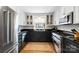Traditional kitchen with stainless appliances, black countertops, white cabinets and a neutral rug on the wooden floor at 1148 Turnbridge Rd, Charlotte, NC 28226