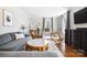 Bright living room featuring a comfortable gray sofa, wood floors, and natural light from large windows at 1148 Turnbridge Rd, Charlotte, NC 28226