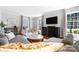 Spacious living room featuring a gray sofa, wood floors, a large TV, and bright natural light from large windows at 1148 Turnbridge Rd, Charlotte, NC 28226